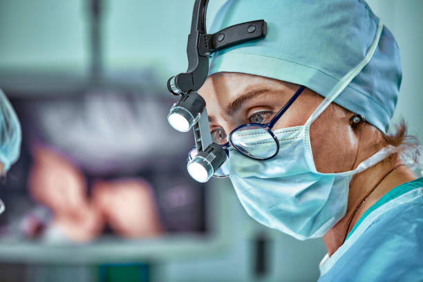 Female surgeon in operation room with reflection in glasses stock photo