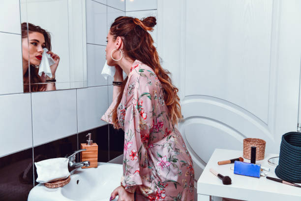 istock Female Taking Off Make Up In Front Of Mirror 1180300307