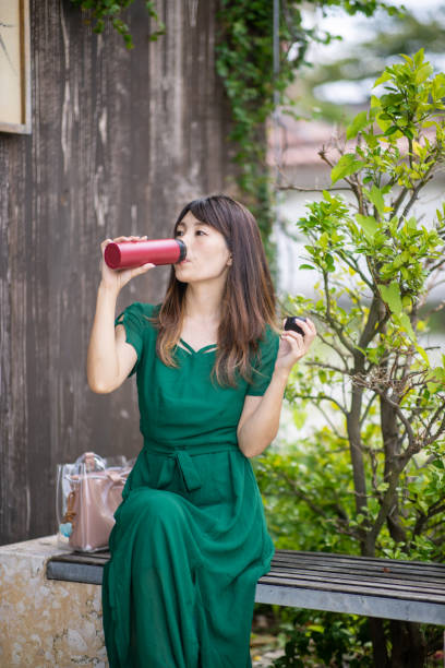 istock Young woman drinking water using reusable bottle 1180302640