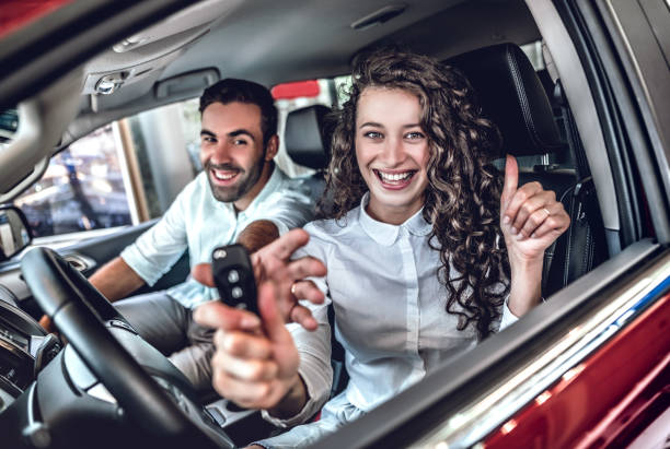 istock Beautiful young couple is smiling in a new car 1180308169