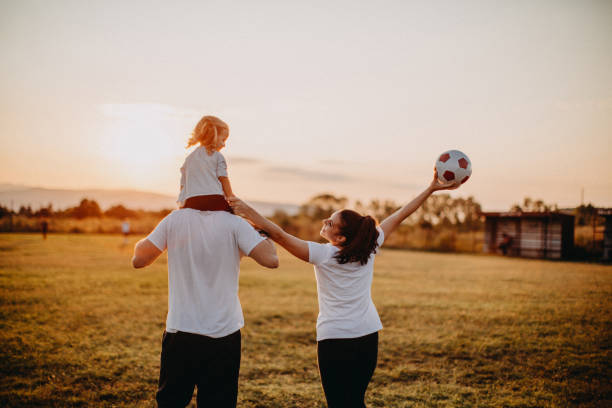 istock Family playing with ball in meadow 1180311768