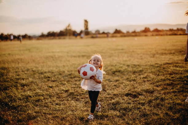 istock Kid running with ball in meadow 1180311913