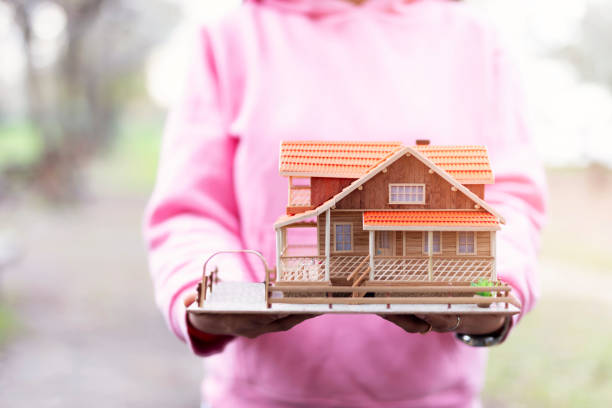 businessman with house model in hand