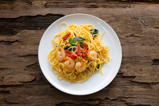 nourriture de spaghetti de mer délicieuse mise sur un plat blanc sur un fond en bois de la vue du haut. - prepared shrimp seafood sauces herb photos et images de collection