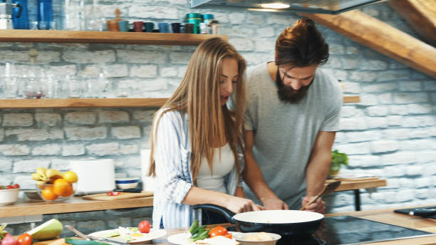 istock Young couple making dinner together at home 1180318946