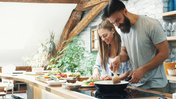 Young couple making dinner together at home stock photo