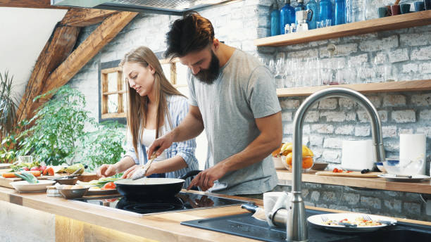 istock Young couple making dinner together at home 1180318957