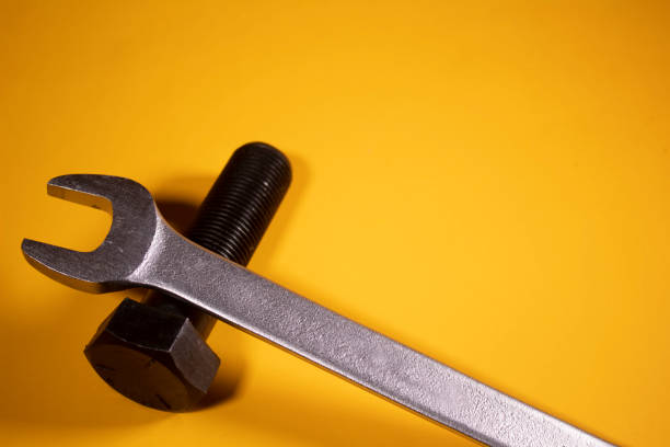 istock Hexagonal wrench with grade 5 screw on a yellow background 1180323299