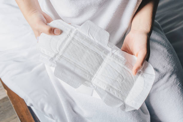 zbliżenie rąk kobiety trzymających podpaski lub podkładkę menstruację przed jej noszeniem. - sanitary pad zdjęcia i obrazy z banku zdjęć