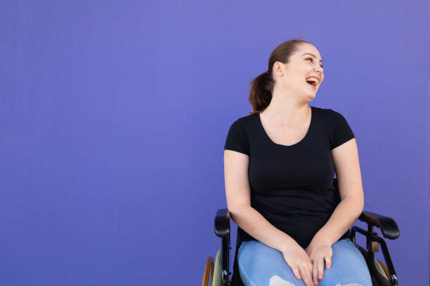 mujer joven incapacitada segura en silla de ruedas - physical impairment wheelchair disabled accessibility fotografías e imágenes de stock