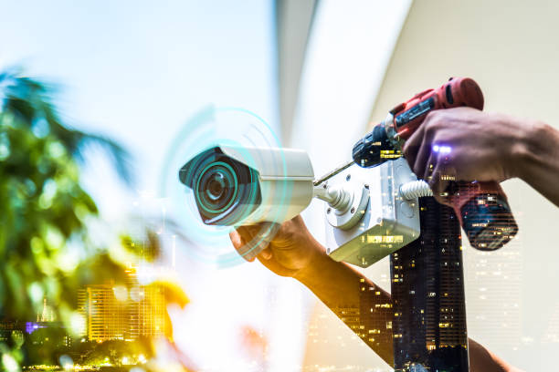 istock Double exposure technician installation CCTV camera on a pole , show signal , blurred background with an infographics city building landscape. 1180325322