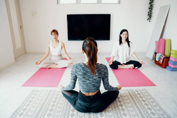 istock Millennial-aged women learning and practicing yoga 1180328279
