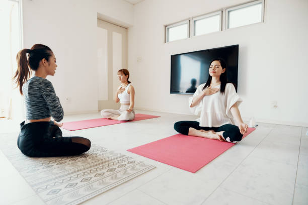 istock Millennial-aged women learning and practicing yoga 1180328603