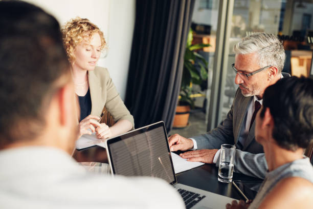 istock Diverse businesspeople working together around a boardroom table 1180329450