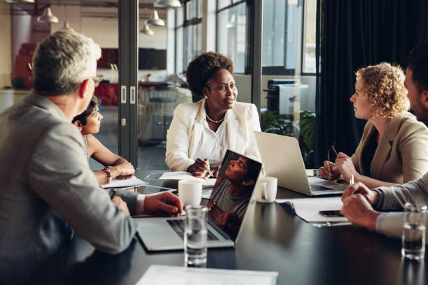 istock Diverse businesspeople discussing work together around a boardroom table 1180330321
