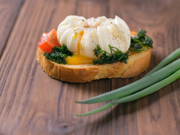istock A piece of toasted bread with a poached egg on a wooden table. 1180330657