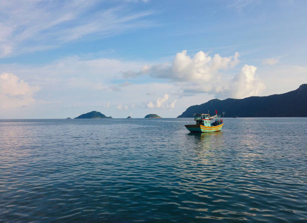 istock fishing boat on the calm water under amazing clear sky 1180332984