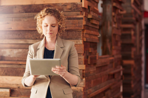 istock Young businesswoman standing in an office hall using a tablet 1180333644