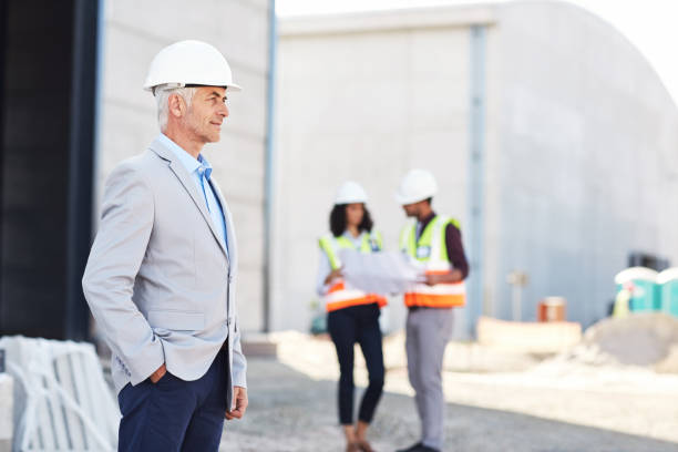 istock Mature engingeer inspecting a building site with his crew 1180335834