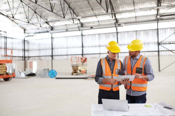 istock Two building engineers wearing safety gear working on a tablet 1180338847