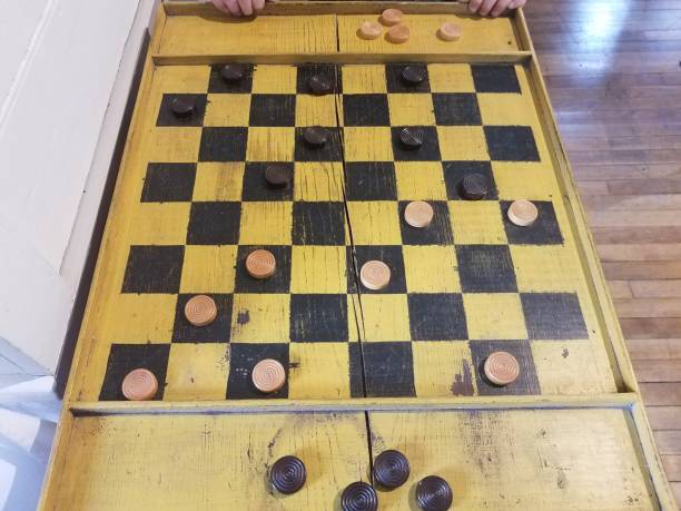 istock wood black and yellow checkerboard with pieces 1180338958