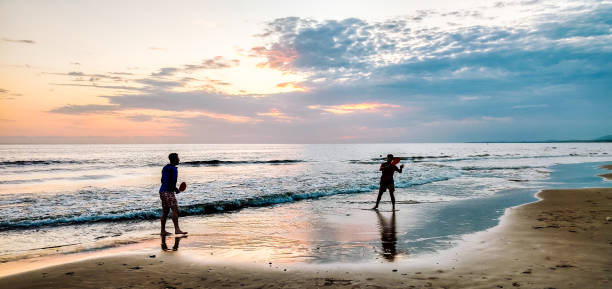 istock sunset: two brothers playing paddle in the beach 1180341188