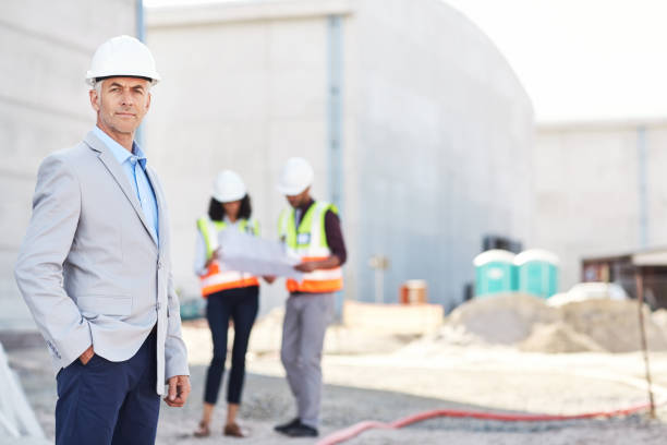 istock Mature engineer and his construction crew inspecting a building site 1180342734