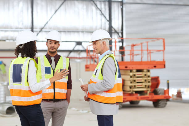 istock Diverse group of building engineers talking together in a warehouse 1180343678