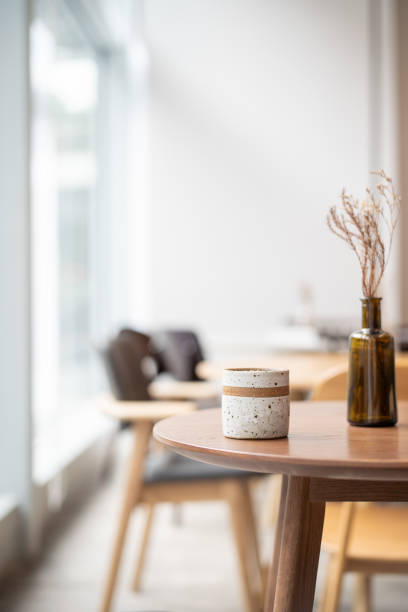 Coffee cup on top of wooden table next to window