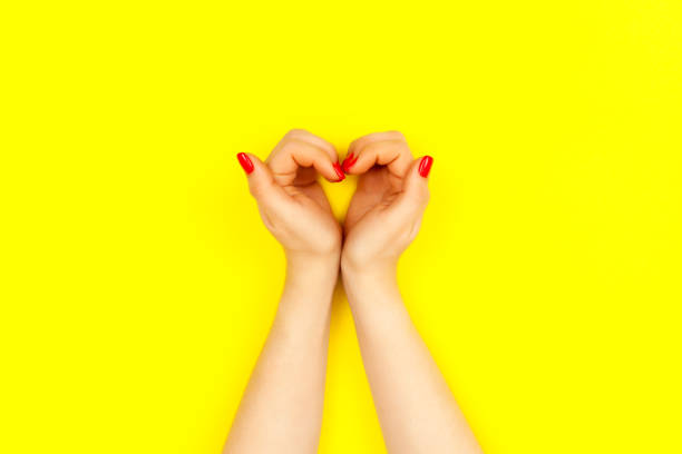 istock Two beautiful woman's hands with red manicure look like heart. 1180345670