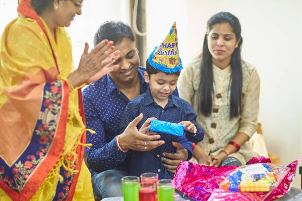istock Indian Father Helping Young Son Open Birthday Present 1180345887