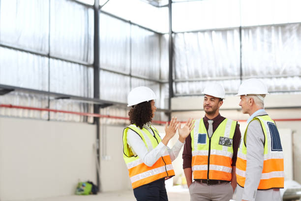 istock Group of diverse building engineers talking together in a warehouse 1180346747