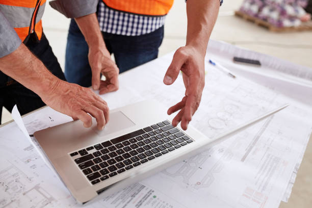 istock Two building engineers discussing blueprints and working on a laptop 1180346952