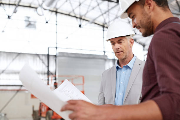 istock Building engineers reading blueprints together during a worksite inspection 1180350239