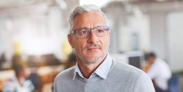 istock Mature businessman standing in an office deep in thought 1180352666