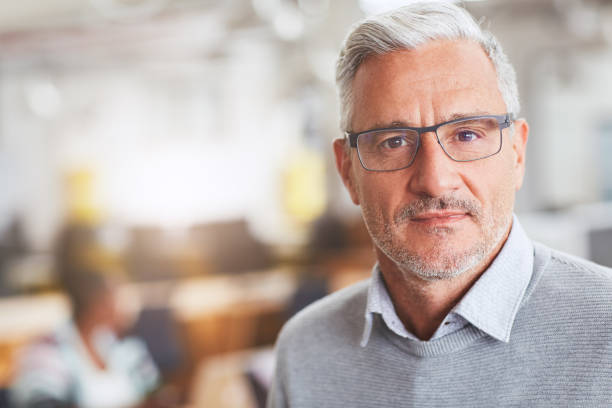 istock Focused mature businessman working in a large modern office 1180352761