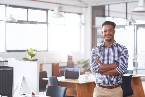 istock Smiling young businesswoman standing in a bright modern office 1180352797
