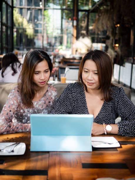 istock Asian women using tablet in cafe together, lifestyle concept. 1180352803