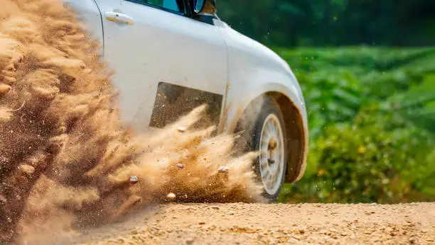 splashing dust and  gravel from rally race car