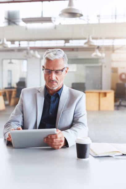 istock Mature businessman working with a tablet at his office desk 1180354519