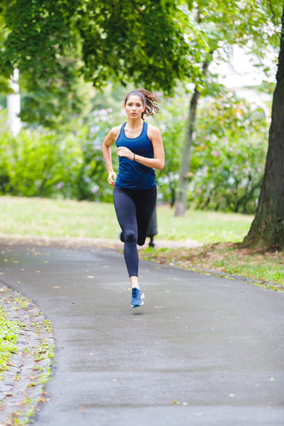 istock Young woman running in the park 1180357723