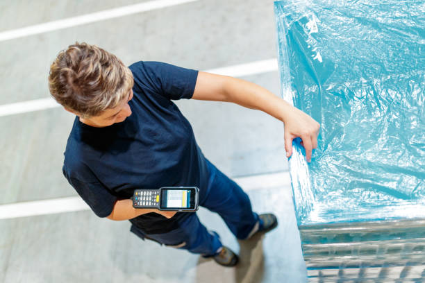 istock High angle view of woman amidst pallets with barcode reader 1180359479