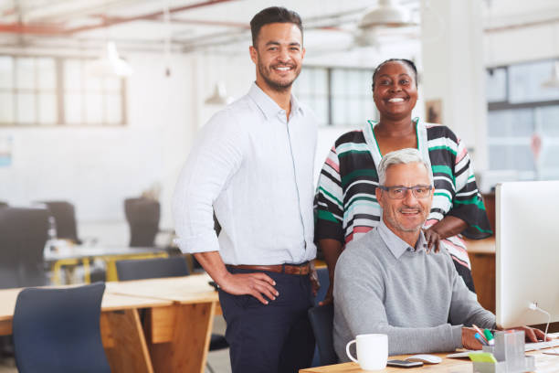 istock Smiling businesspeople working together on a computer in an office 1180360272
