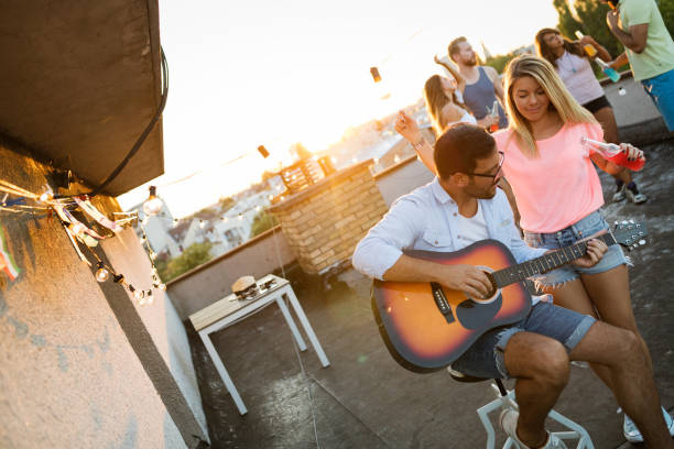 istock Group of young people having fun at a summertime party, at sunset 1180360441