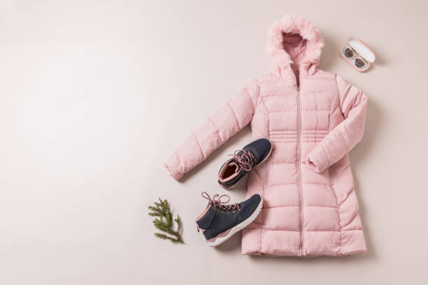 istock Winter outfit for women - pastel pink down jacket and boots. 1180363136