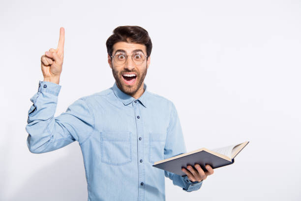 istock Photo of multiethnic clever guy holding planner indicating finger on black board explaining students theorem wear casual denim shirt isolated white color background 1180368936