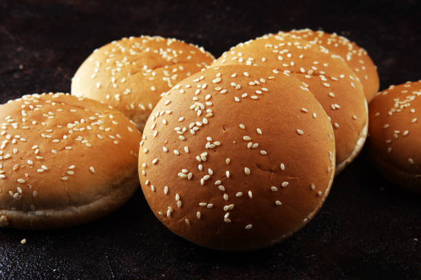istock Fresh homemade burger buns with sesame on dark background 1180369127