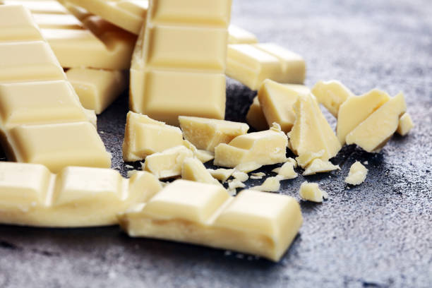 istock white broken chocolate and cocoa bar. Pieces of white chocolate on rustic background 1180370334