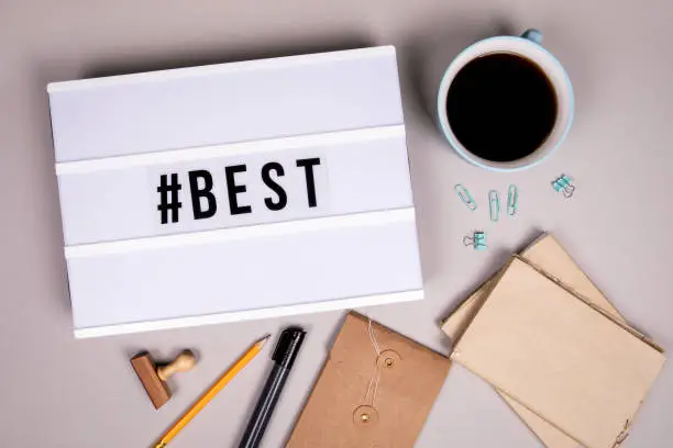 Photo of Hashtag with word Best. White lightbox on a office desk