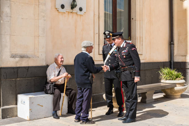 Carabinieri discuss with two elderly people in the town square Syracuse Sicily/ Italy - october 04 2019: Carabinieri discuss with two elderly people in the town square soldier on the wall stock pictures, royalty-free photos & images